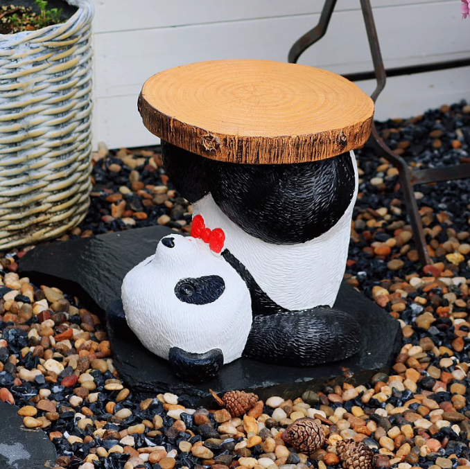 panda holding wood on its leg stool